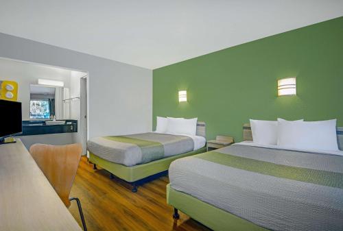 a hotel room with two beds and a desk at Motel 6-Tallahassee, FL - Downtown in Tallahassee