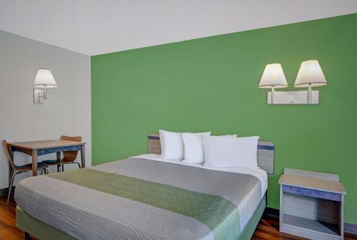 a bed in a room with a green wall at Motel 6-Tallahassee, FL - Downtown in Tallahassee