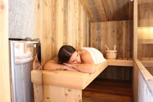 a woman is laying in a sauna at Appartamenti Diva in Livigno