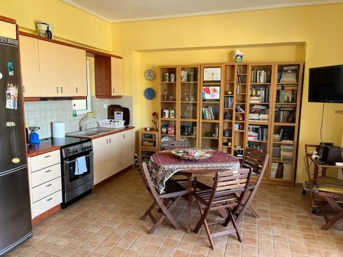 a kitchen with a table with chairs and a refrigerator at Xylokastro - Wayhome PHIVI in Xylokastron