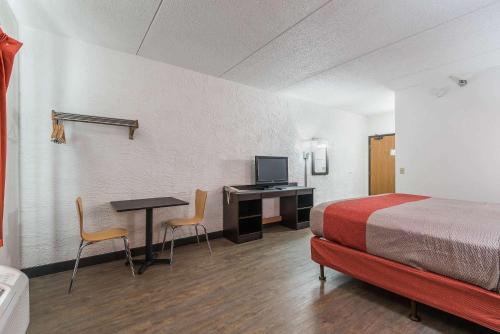 ein Hotelzimmer mit einem Bett und einem Schreibtisch mit einem Computer in der Unterkunft Motel 6-Bridgeview, IL in Bridgeview