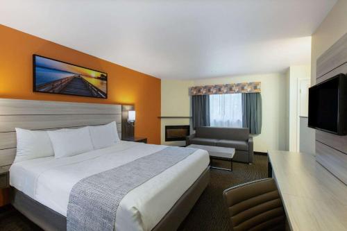 a hotel room with a large bed and a television at Days Inn by Wyndham Monterey-Fisherman's Wharf Aquarium in Monterey