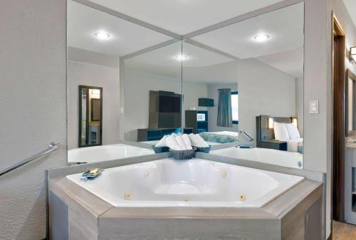 bañera grande en una habitación con espejo grande en Motel 6-Cedar Rapids, IA - Airport en Cedar Rapids