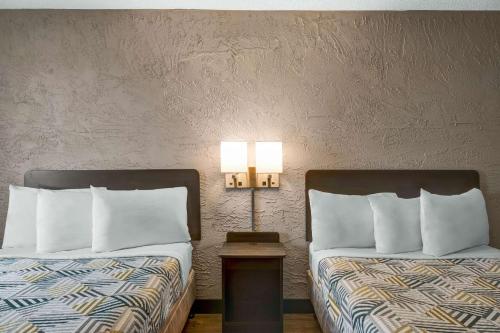 a hotel room with two beds and a table with two lamps at Motel 6-Elk Grove Village, IL - O'Hare in Elk Grove Village