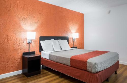 a bedroom with a large bed with an orange wall at Motel 6-Prospect Heights, IL in Prospect Heights