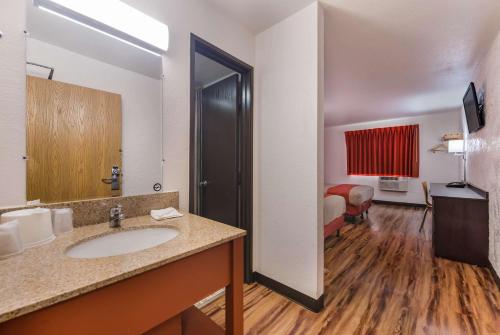 a bathroom with a sink and a room with a bed at Motel 6-Saint Paul, MN - I-94 in Saint Paul