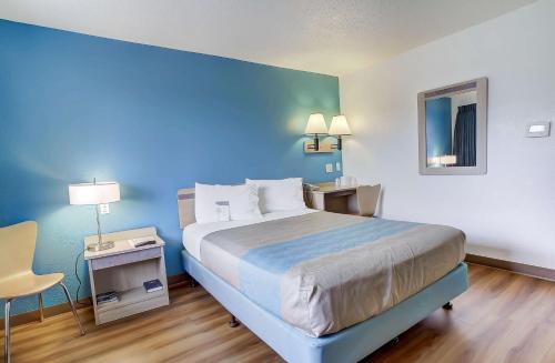 a bedroom with a bed with a blue wall at Motel 6-Coos Bay, OR in Coos Bay