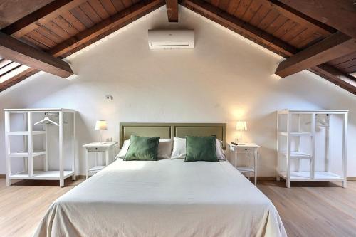 a bedroom with a large bed with two white shelves at Residence il Cascinetto in Pavia