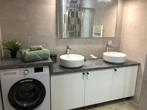 a bathroom with two sinks and a washing machine at Vimachlea in Bourg-Saint-Christophe