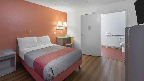 a small hotel room with a bed and a bathroom at Motel 6-Medford, OR - North in Medford