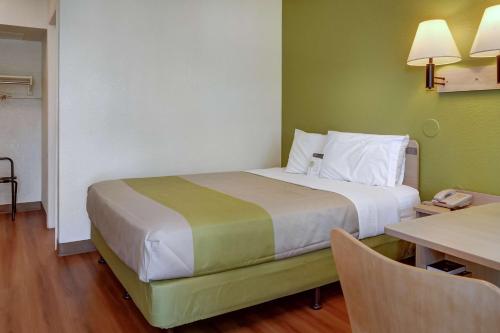 a hotel room with a large bed and a table at Motel 6-Eugene, OR - South Springfield in Eugene