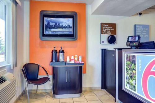 a room with a tv on the wall and a bar at Motel 6-Eugene, OR - South Springfield in Eugene