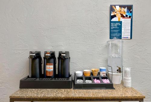 a counter with bottles on a table with a wall at Motel 6-Oak Creek, WI in Oak Creek