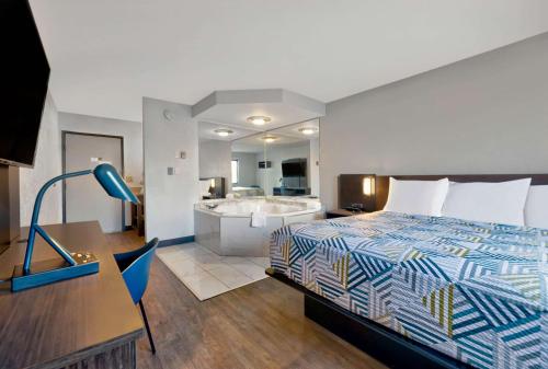 Motel 6-Oak Creek, WI في أوك كريك: غرفة في الفندق مع سرير وحوض استحمام