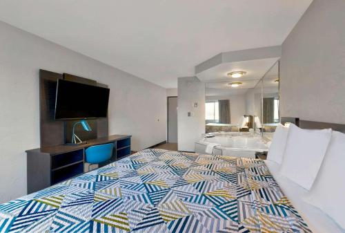 a hotel room with a large bed and a bathroom at Motel 6-Oak Creek, WI in Oak Creek