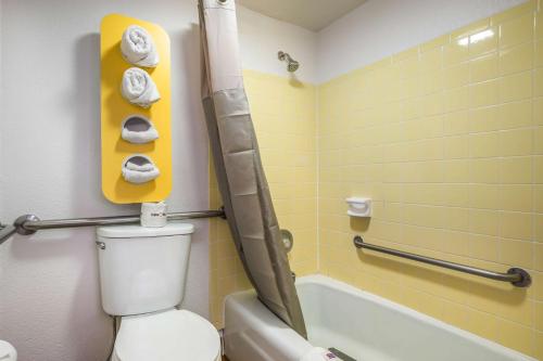 a bathroom with a toilet and a bath tub with towels at Motel 6-Madison, WI - East in Madison