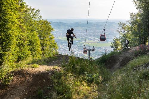 a person riding a bike on a hill with a ski lift at Hotel Bau Maribor in Maribor