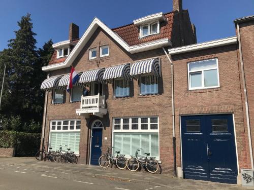 een bakstenen gebouw met buiten geparkeerde fietsen bij Guesthouse Thoez in Maastricht