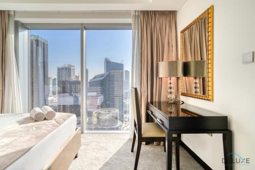 1 dormitorio con escritorio y 1 cama con ventana en Decadent 2BR in The Address Residences Dubai Marina by Deluxe Holiday Homes, en Dubái