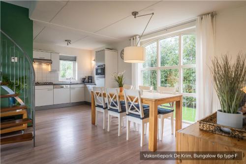 a kitchen and dining room with a table and chairs at Vakantiepark De Krim Texel in De Cocksdorp