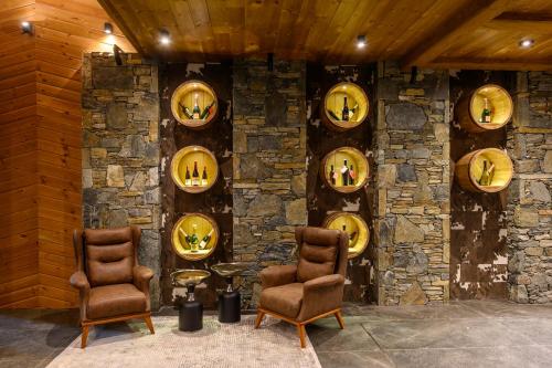 a room with a stone wall with two chairs and plates at Grand Hotel Therme in Banya
