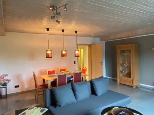 a living room with a blue couch and a table at Ferienwohnung Casa Herrmann in Losheim