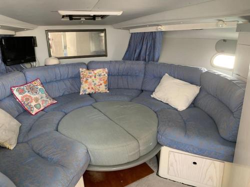 a living room with a blue couch in a trailer at Bateau à quai au Brusc, confort, coucher de soleil, calme in Six-Fours-les-Plages