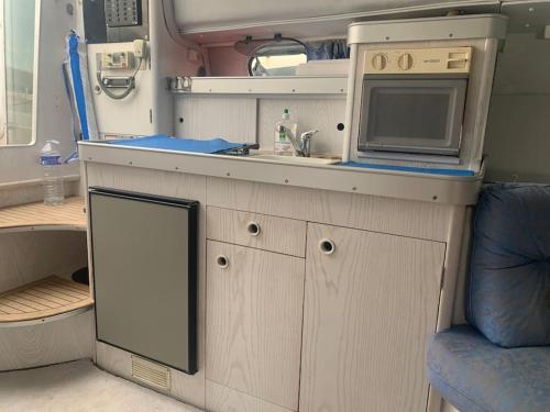 a kitchen with a sink and a microwave in an rv at Bateau à quai au Brusc, confort, coucher de soleil, calme in Six-Fours-les-Plages