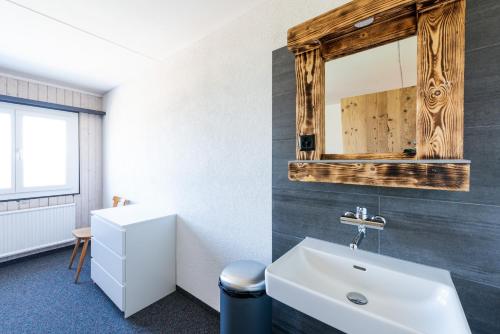 een badkamer met een witte wastafel en een spiegel bij Heuberge in Fideris Dorf
