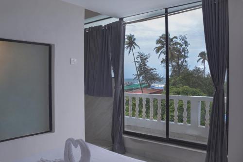 a bedroom with a window with a view of the ocean at Sandbanks Beach Resort in Arambol