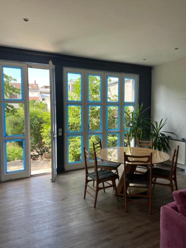 un salon avec une table, des chaises et des fenêtres dans l'établissement DE LA CROIX, à Nanterre