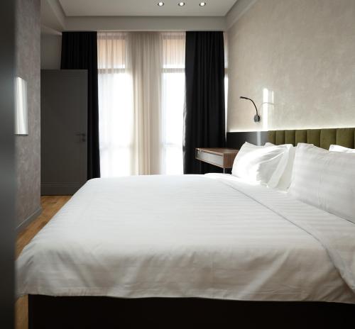 a large white bed in a room with a window at Hilltop North Avenue by Stellar Hotels, Yerevan in Yerevan