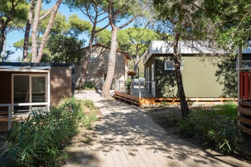 a house with a pathway next to a house at Camping Il Capannino Glamping Village in Marina di Bibbona
