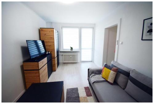 un soggiorno con divano e finestra di Color24 Centrum Nisko a Nisko