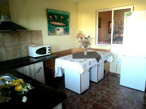 a kitchen with a small table and a microwave at La Casuca Azul in Ruiloba