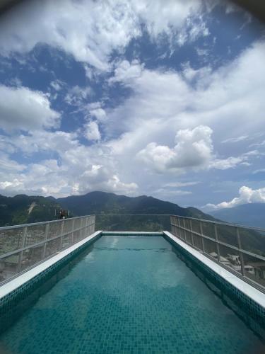 a swimming pool on top of a building with a blue sky at Hotel Maenamla Namchi - yagi group in Namchi