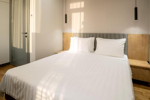 a large white bed with white sheets and pillows at Hilltop North Avenue by Stellar Hotels, Yerevan in Yerevan