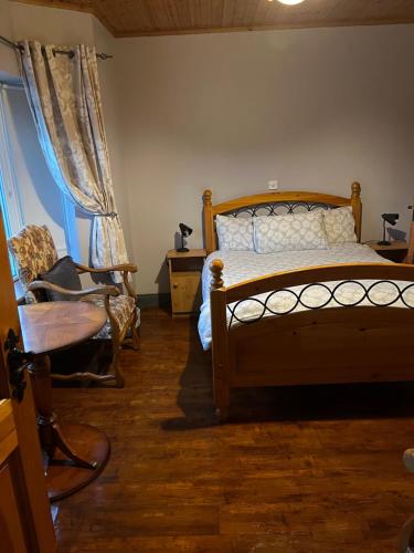 a bedroom with a bed and a chair and a window at Doughlasha House V93RX64 in Killarney