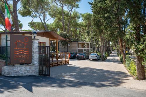 een poort bij de ingang van een caravanpark met geparkeerde auto's bij Camping Il Capannino Glamping Village in Marina di Bibbona