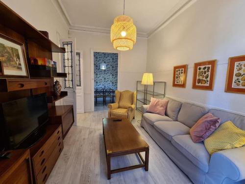 - un salon avec un canapé et une télévision dans l'établissement 122A - Emblemática vivienda en Playa San Lorenzo, à Gijón