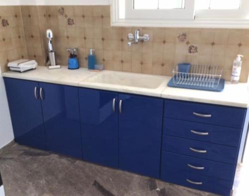 a kitchen with blue cabinets and a sink at Κατοικία 80 τ.μ. δίπλα από την θάλασσα στην Ελιά. in Elia Laconias