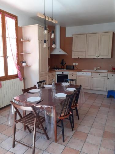 une cuisine avec une table et des chaises dans une cuisine dans l'établissement Maison du Guier 4 ou 6 personne au coeur du massif, à Saint-Pierre-de-Chartreuse