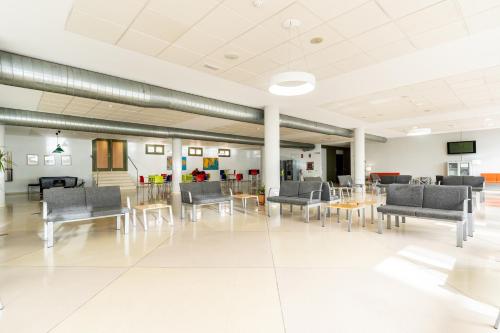 an empty waiting room with chairs and tables at Albergue Inturjoven Jaen in Jaén
