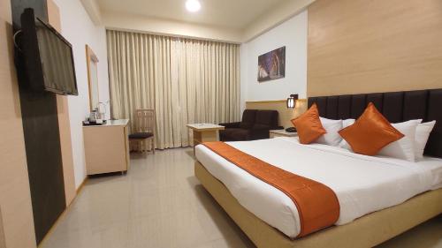 a hotel room with a bed and a television at Sterling V Grand Madurai in Madurai