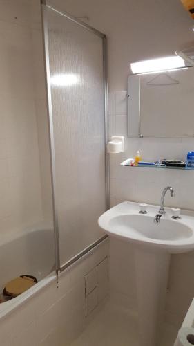 een witte badkamer met een wastafel en een douche bij Appartement au pied des pistes de st lary in Saint-Lary-Soulan
