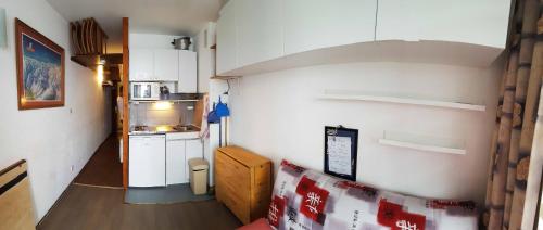 een kleine kamer met een keuken met witte kasten bij Appartement au pied des pistes de st lary in Saint-Lary-Soulan