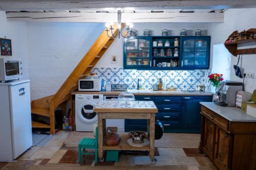 una cocina con armarios azules y una escalera. en Szívecske Ház - Hegymagas, en Hegymagas