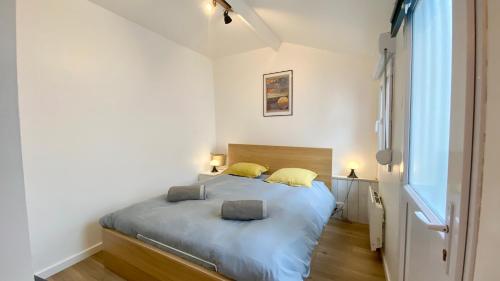 a bedroom with a bed with two pillows on it at Petite maison de pêcheur au coeur du Crotoy in Le Crotoy