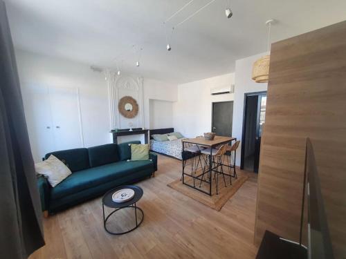 ein Wohnzimmer mit einem Sofa und einem Tisch in der Unterkunft -Garrigue- Face à la Cité médiévale studio terrasse classé 4☆ in Carcassonne