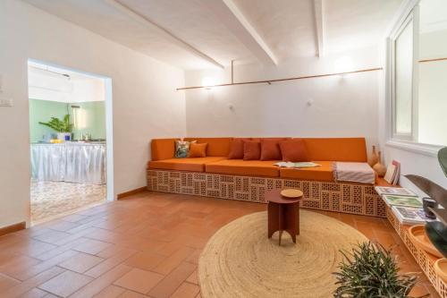 ein Wohnzimmer mit einem orangenen Sofa und einem Tisch in der Unterkunft Memory Atelier - apartment in Florence in Florenz